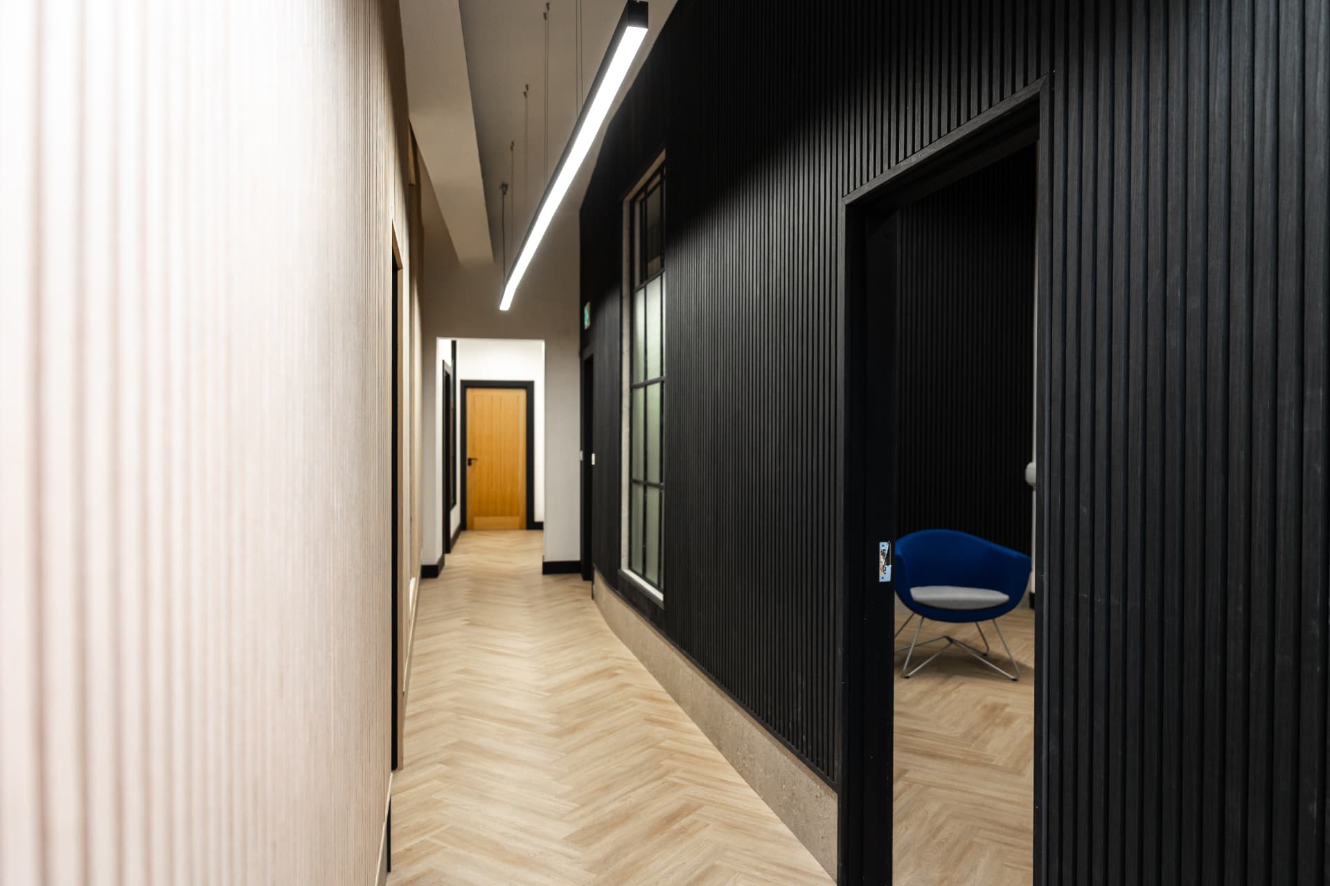 Patrick's corridor with blue chairs visible in a side room