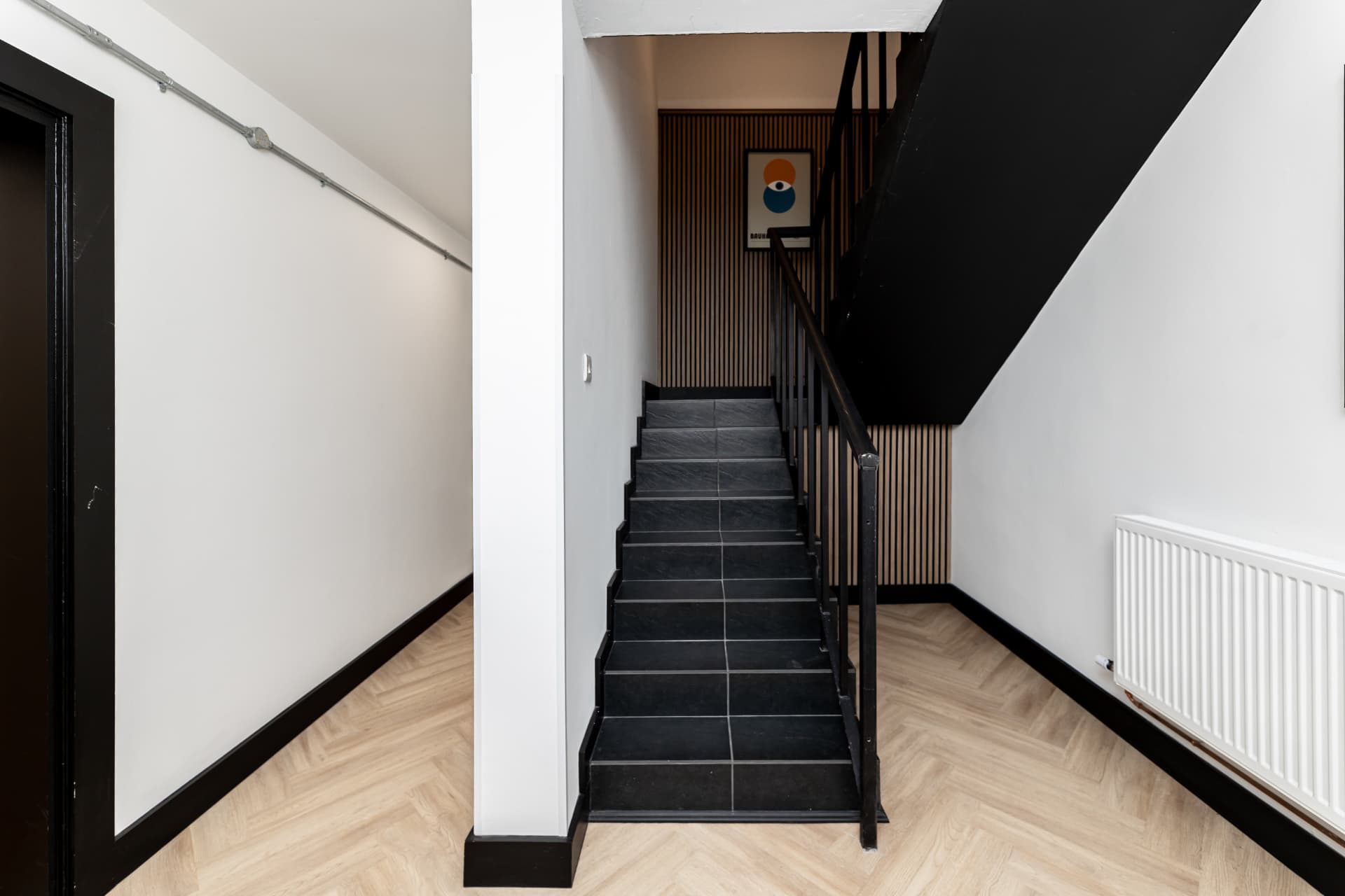 Stairwell at Patrick's with dark stairs and wood slat detailing