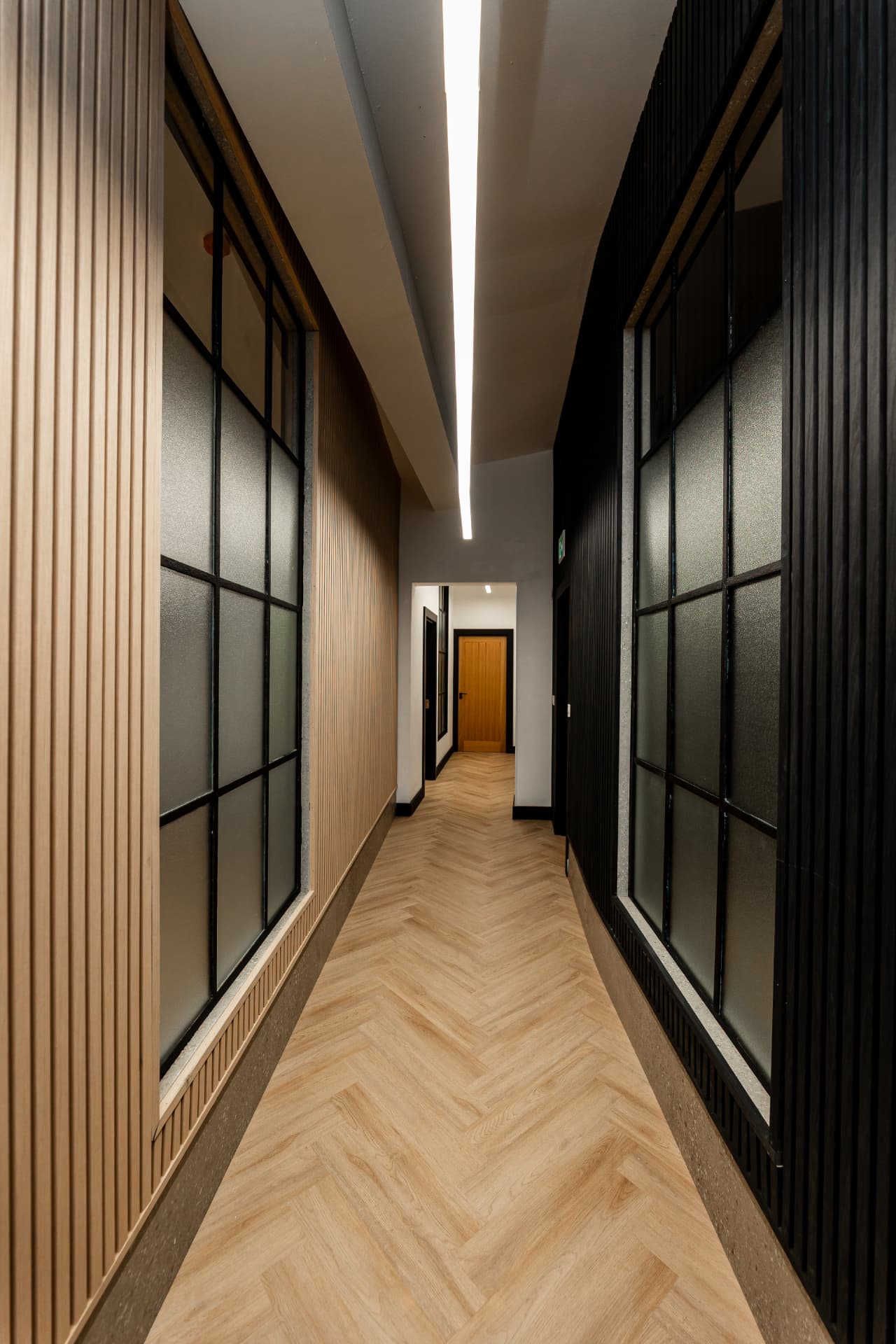 Patrick's corridor with vertical wood slats and recessed lighting